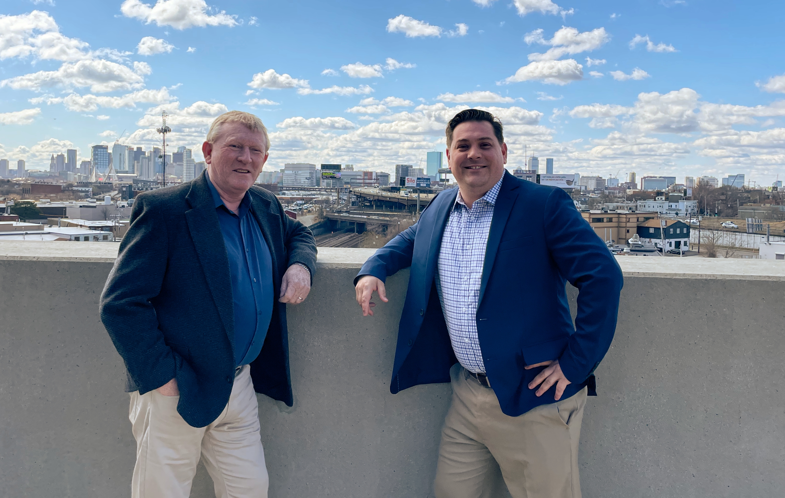 Picture of Steve Dowdy and Mike Smyth in front of a boston Skyline.